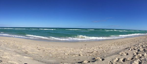 Scenic view of beach against clear blue sky