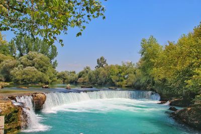 Scenic view of waterfall against sky