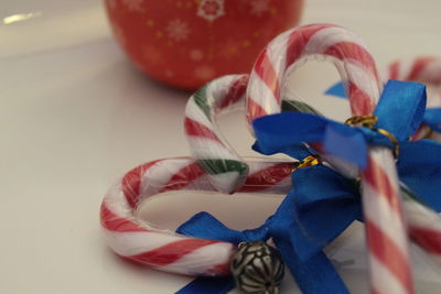 Close-up of candy canes with blue ribbons on table