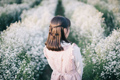 Woman standing by plants outdoors