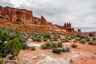 View of rock formations on landscape against cloudy sky