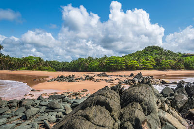 Scenic view of rocks by river against sky