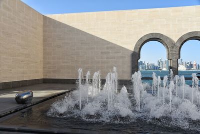 Water flowing from bridge against sky