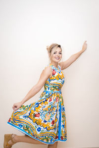 Portrait of smiling young woman against white background