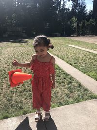 Full length of girl holding traffic cone standing at park