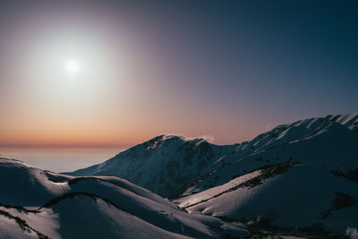 Scenic view of snowcapped mountains against clear sky