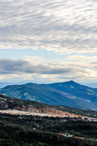 Scenic view of mountains against cloudy sky