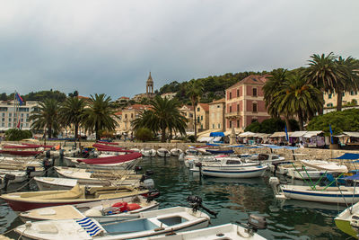 Boats moored at harbor against buildings in city