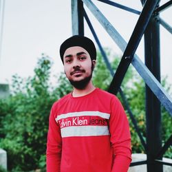 Portrait of young man standing against trees