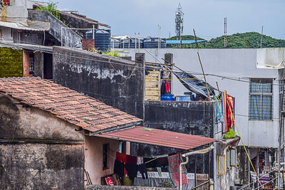 Clothes drying on clothesline by building against sky