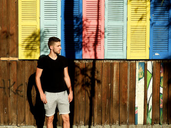 Full length of young man standing against wall