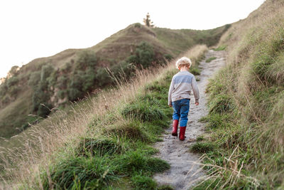 Preschool aged child walking on hillside path