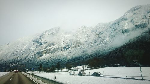 Snow covered road against clear sky