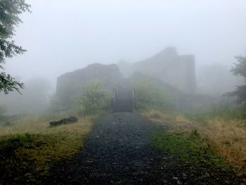 Scenic view of landscape against sky during foggy weather