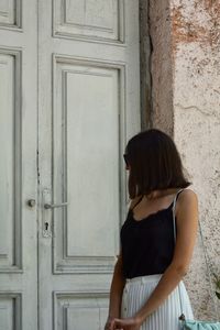 Woman standing against closed door