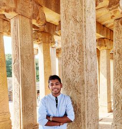 Portrait of a smiling young man standing outside building