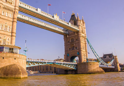 Arch bridge over river against sky in city