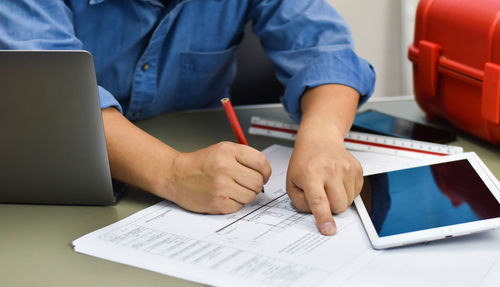 Midsection of man using laptop on table