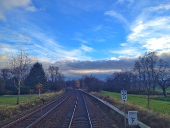 Railroad track against cloudy sky