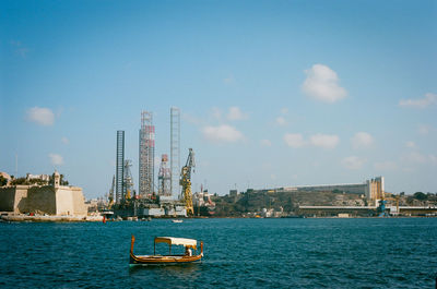 Ship in sea against buildings in city