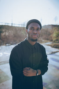 Portrait of young man standing against sky