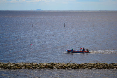 People on sea against sky