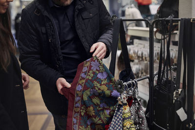 Couple choosing scarf in department store