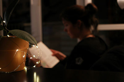 Young woman reading a book indoors on a rainy day