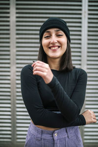 Happy young woman against metallic shutter