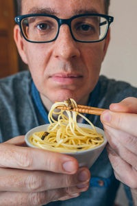Portrait of man having noodles and worms in restaurant