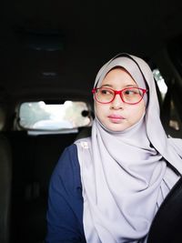 Mid adult woman wearing eyeglasses in car