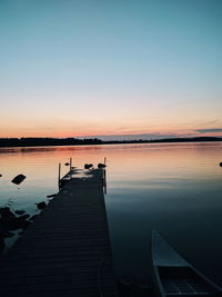 Pier over lake against sky during sunset