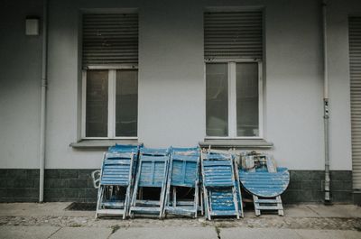 Empty chairs and tables against building