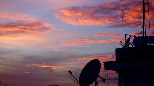  silhouette of rooftop satellite dishes at sunset