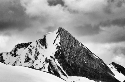 Snow covered mountain against cloudy sky