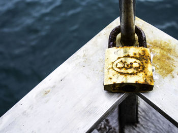 High angle view of padlock attached to boat railing in sea
