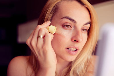 Close-up of young woman applying nail