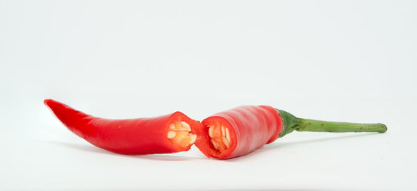 Close-up of red chili peppers against white background