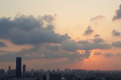 Buildings in city against sky during sunset