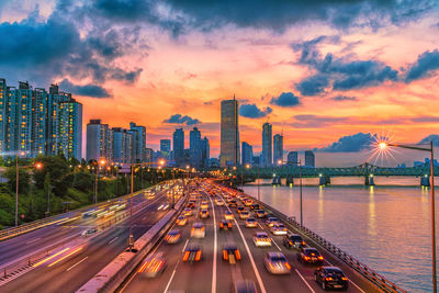 Panoramic view of illuminated city buildings against sky during sunset