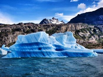Scenic view of icebergs in sea against sky