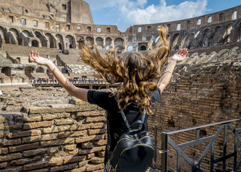 Rear view of girl with long hair at colosseum