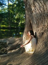 Woman sitting by tree