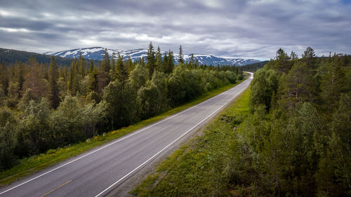 Road amidst trees against sky