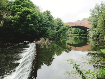Arch bridge over river against sky