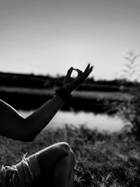 Cropped hand of woman with arms raised against sky