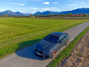 Scenic view of road amidst field against sky