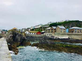 Houses by sea against sky