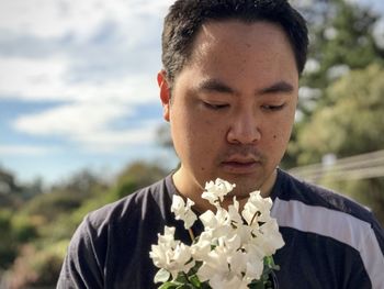 Close-up portrait of a young man holding flower