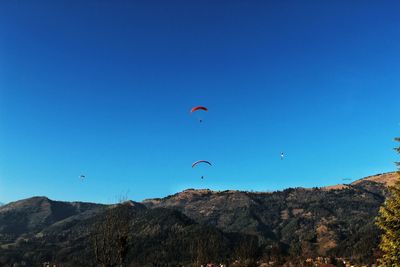 Low angle view of kite flying against clear blue sky